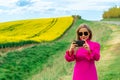 Beautiful women walking in amazing field of yellow rapeseed in the countryside. Canola oil plants Royalty Free Stock Photo