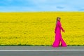 Beautiful women walking in amazing field of yellow rapeseed in the countryside. Canola oil plants Royalty Free Stock Photo