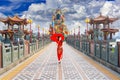 Beautiful women wearing dresses red cheongsam holding an umbrella walking on the bridge at Zuoying Yuandi temple,Taiwan Royalty Free Stock Photo