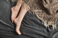 Beautiful womens feet on a gray blanket. Women sleeping in a cozy bed Royalty Free Stock Photo