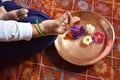 Beautiful womens hand performing yoga postures in the morning at home with flowers and water in copper plate Royalty Free Stock Photo