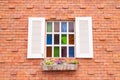 Beautiful wood window with multi color glass and brick wall Royalty Free Stock Photo