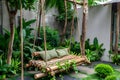 Beautiful wooden cozy swing hanged with rope in a green home garden backyard with green plants and trees and relaxation morning Royalty Free Stock Photo