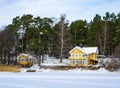 Beautiful wooden houses in the winter. Traditional villas cottages in Sweden by the sea or lake are painted yellow. Village eco Royalty Free Stock Photo