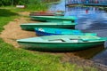 Beautiful wooden multicolored boats with oars on the beach for walks along the river, lake, sea, ocean in a nature park