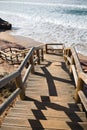 Beautiful wooden stairs going down to atlantic ocean on sandy beach Royalty Free Stock Photo