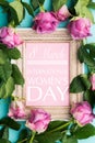 Beautiful wooden vintage picture frame with Happy Womens Day wish and fresh pink roses. Happy Women`s Day Flat Lay Background. Royalty Free Stock Photo