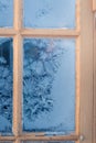 Beautiful wooden window with frozen ice flowers in Norwegian town. Royalty Free Stock Photo