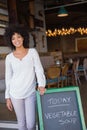 Beautiful worker leaning on chalkboard