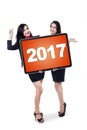 Beautiful workers with numbers 2017 on a board