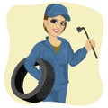 Beautiful working woman in car repair service holding tyre and wheel wrench Royalty Free Stock Photo