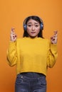 Beautiful worried nervous young adult person crossing fingers for good luck wishing to successfully pass exam. Royalty Free Stock Photo