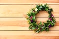 Beautiful wreath made of flowers and leaves on wooden background, top view. Space for text Royalty Free Stock Photo