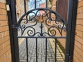 Beautiful wrought iron gate pattern with carvings between brick columns Royalty Free Stock Photo