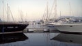 Beautiful yachts stand on pier on beautiful sky reflected in water. Action. Beautiful expensive yachts with masts on Royalty Free Stock Photo