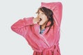 Beautiful yawning woman in pink bathrobe. Royalty Free Stock Photo