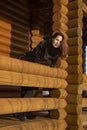 A beautiful 45-year-old woman with red hair poses on the veranda of a log house