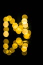 Beautiful yellow bokeh effect with reflection with a nice black background. photography art, light bokeh, reflection, night Royalty Free Stock Photo