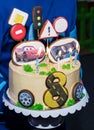 Beautiful yellow cake with gingerbread in the form of cars and road signs. Vertical image