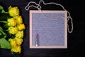 Beautiful yellow flowers and desk for text. Bouquet of roses on a black wooden background, copyspace. Beads of pearls and lipstick Royalty Free Stock Photo