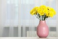 Beautiful yellow flowers in vase on table at home, space for text Royalty Free Stock Photo