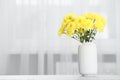 Beautiful yellow flowers in vase on table at home, space for text Royalty Free Stock Photo