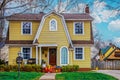 Beautiful yellow house with picturesque roofline and window with childs toy car parked in front - Curb appeal