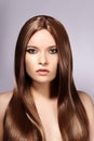 Beautiful yong Woman with Long Straight Brown Hair. Fashion Model with Smooth Gloss Hairstyle. Keratine Treatment Royalty Free Stock Photo