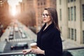 Beautiful young adult business woman drinking coffee in the city at morning time. Royalty Free Stock Photo