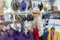 Beautiful young adult caucasian bald woman choosing and trying on hat in department retail store at shopping mall. Portrait of Royalty Free Stock Photo