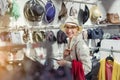 Beautiful young adult caucasian bald woman choosing and trying on hat in department retail store at shopping mall. Portrait of Royalty Free Stock Photo