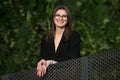 Beautiful young adult smiling woman with glasses smiling outdoors in the park.