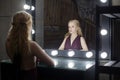 Beautiful young adult woman blonde looking at her reflection in a dressing room mirror Royalty Free Stock Photo