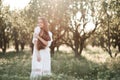 Beautiful young adult woman 29-30 year old with long blonde hair wear stylish white dress standing in garden over green nature bac