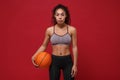 Beautiful young african american sports fitness basketball player woman in sportswear working out isolated on red Royalty Free Stock Photo