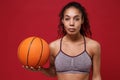 Beautiful young african american sports fitness basketball player woman in sportswear working out isolated on red Royalty Free Stock Photo