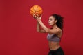 Beautiful young african american sports fitness basketball player woman in sportswear working out isolated on red Royalty Free Stock Photo