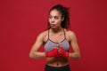 Beautiful young african american sports fitness boxer woman in sportswear posing working out isolated on red background Royalty Free Stock Photo