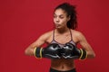 Beautiful young african american sports fitness boxer woman in sportswear posing working out isolated on red background Royalty Free Stock Photo