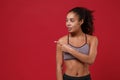 Beautiful young african american sports fitness woman in sportswear posing working out isolated on red background in Royalty Free Stock Photo