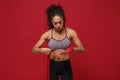 Beautiful young african american sports fitness woman in sportswear posing working out isolated on red background. Sport Royalty Free Stock Photo