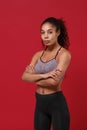 Beautiful young african american sports fitness woman in sportswear posing working out isolated on red background studio Royalty Free Stock Photo