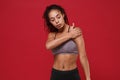 Beautiful young african american sports fitness woman in sportswear posing working out isolated on red background studio Royalty Free Stock Photo