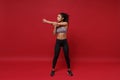 Beautiful young african american sports fitness woman in sportswear posing working out isolated on red background in Royalty Free Stock Photo