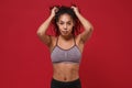 Beautiful young african american sports fitness woman in sportswear posing working out isolated on red wall background Royalty Free Stock Photo