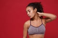 Beautiful young african american sports fitness woman in sportswear posing working out isolated on red wall background Royalty Free Stock Photo