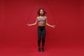 Beautiful young african american sports fitness woman in sportswear posing working out  on red background studio Royalty Free Stock Photo