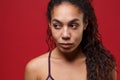 Beautiful young african american sports fitness woman in sportswear posing working out  on red wall background Royalty Free Stock Photo