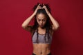 Beautiful young african american sports fitness woman in sportswear posing working out  on red wall background Royalty Free Stock Photo