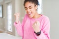 Beautiful young african american woman with afro hair excited for success with arms raised celebrating victory smiling Royalty Free Stock Photo